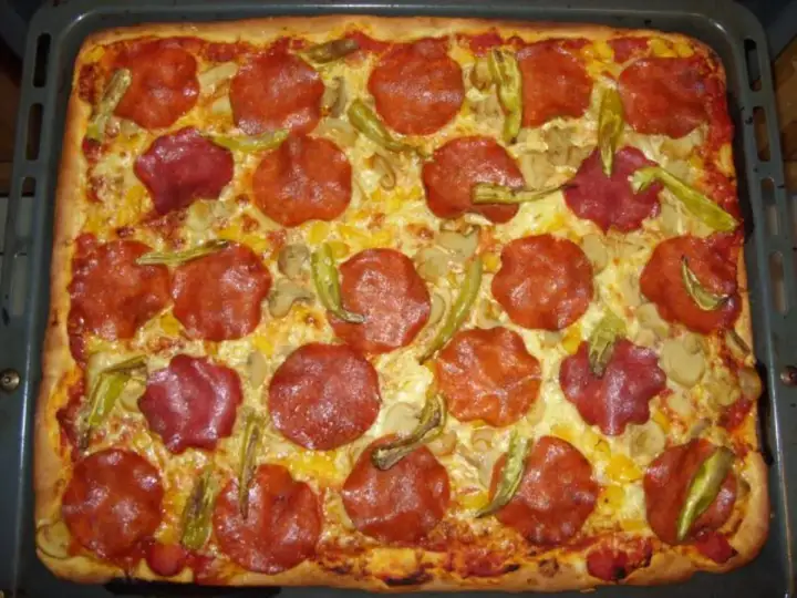 Rechteckige Pizza mit viel Salami, Pilzen und Paprika. Ein Genuss für jeden Pizzaliebhaber!